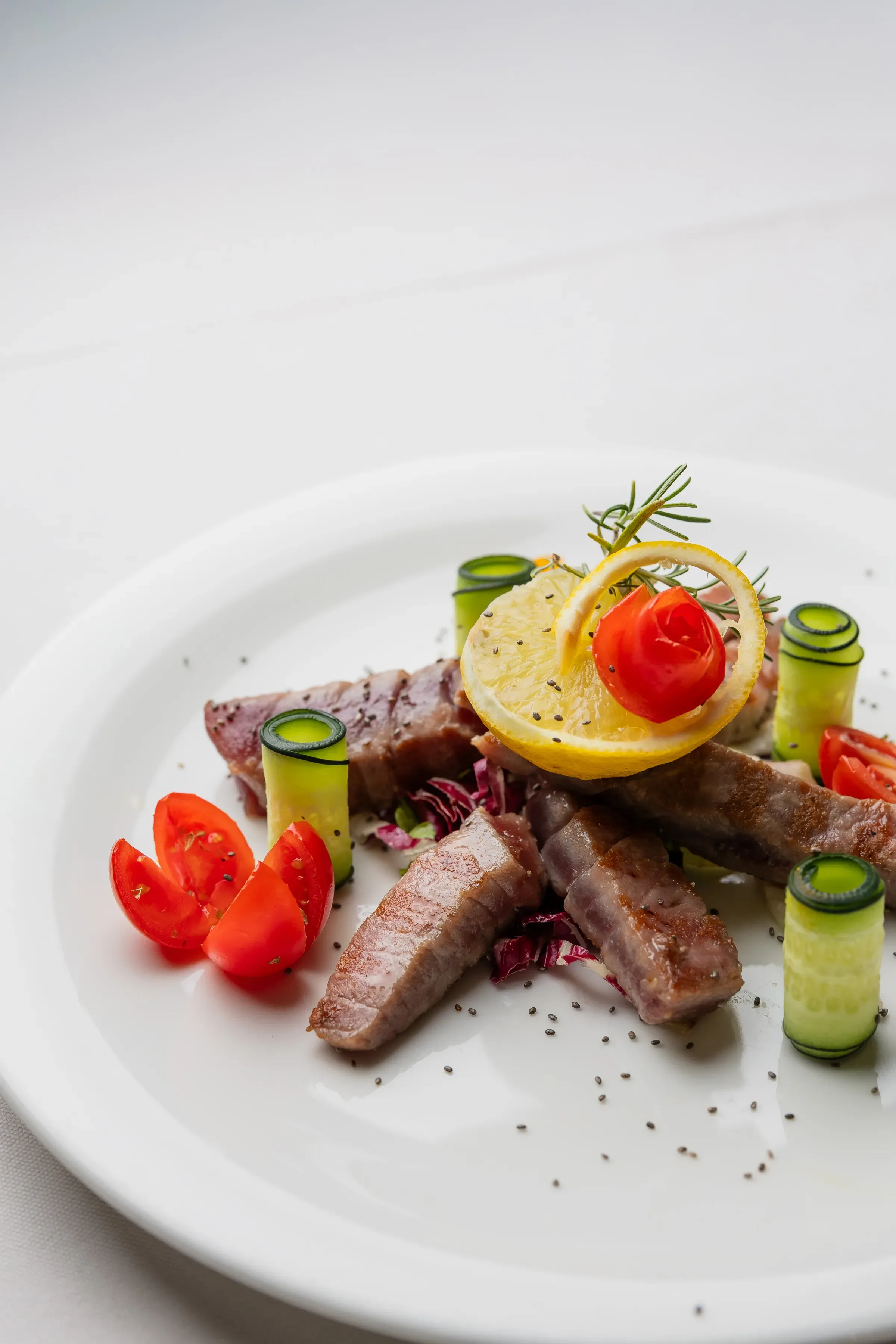 Bistecca servita con zucchine, pomodorini e limone decorativo