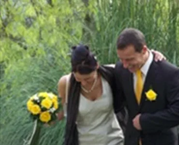 Coppia felice al matrimonio con bouquet di rose gialle