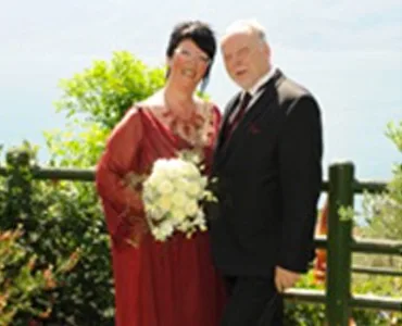 Coppia elegante posa per una foto di matrimonio in giardino