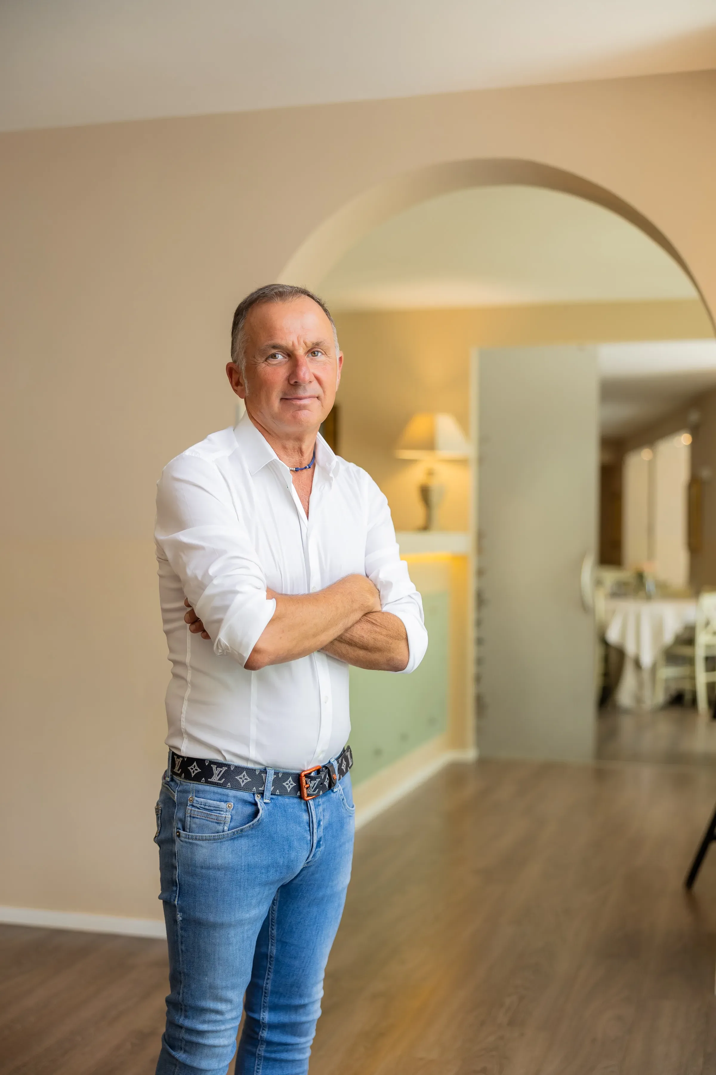 Uomo in camicia bianca in posa in un ambiente elegante