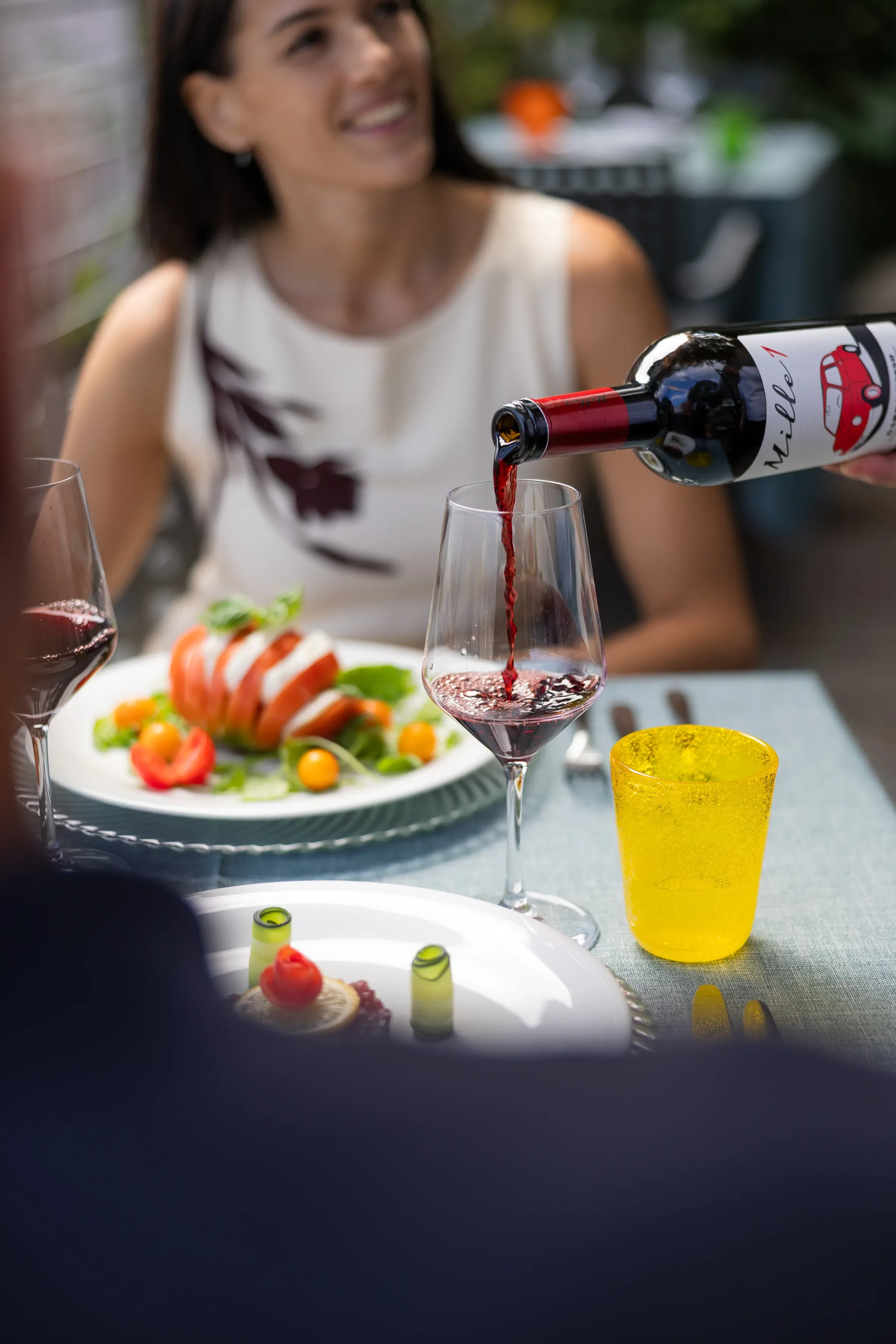 Vino rosso versato in un bicchiere durante un pranzo all'aperto